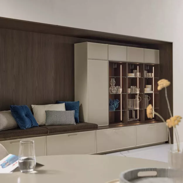 Moderne Nolte Küche Evora in Greige Softmatt mit integrierter Sitzbank und beleuchteter Vitrine – stilvolle Wohnküche von Willemsen Küchen.