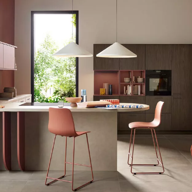 Designküche von Nolte in Soft Lack Hennarot Softmatt mit Holzfronten in Noce Marone und Kücheninsel – elegante Wohnküche von Willemsen Küchen.