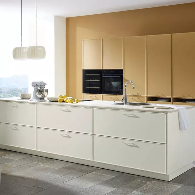 Moderne Nolte Küche Evora in Caramel und Magnolia Softmatt mit großzügiger Kücheninsel und klaren Fronten – hochwertige Einbauküche von Willemsen Küchen.